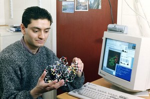 view Researcher with 3-D model of protein