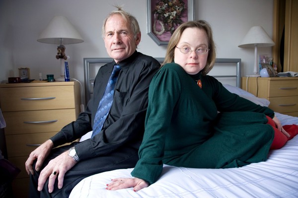 Adult couple sitting on a bed, Down's syndrome