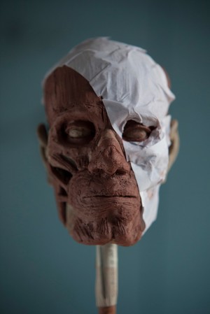 view Human head sculpted in clay, preparing to apply the skin