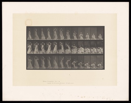 A woman taking a pot from her head and putting on ground. Collotype after Eadweard Muybridge, 1887.