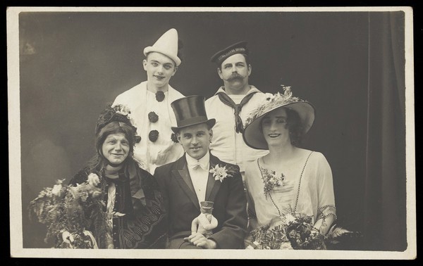 Five men dressed in theatrical costume including a bride and groom.