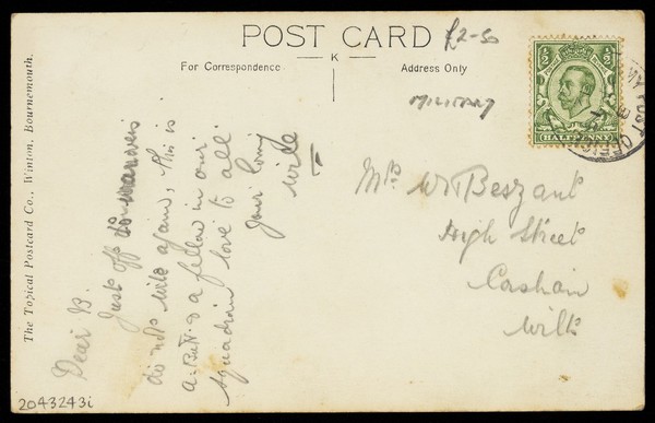 Two soldiers embracing on a bale of hay, one in drag. Photographic postcard, 191-.