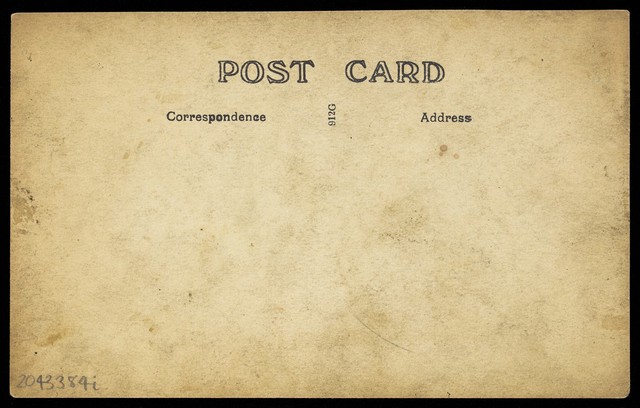 Two sailors, one in drag, pose on deck holding props. Photographic postcard, 191-.