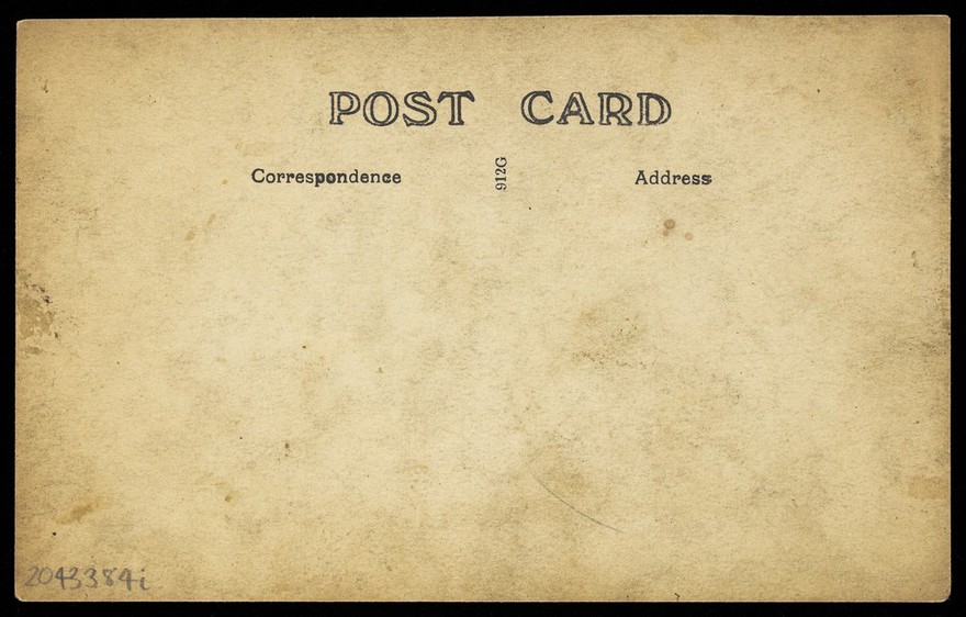 Two sailors, one in drag, pose on deck holding props. Photographic postcard, 191-.