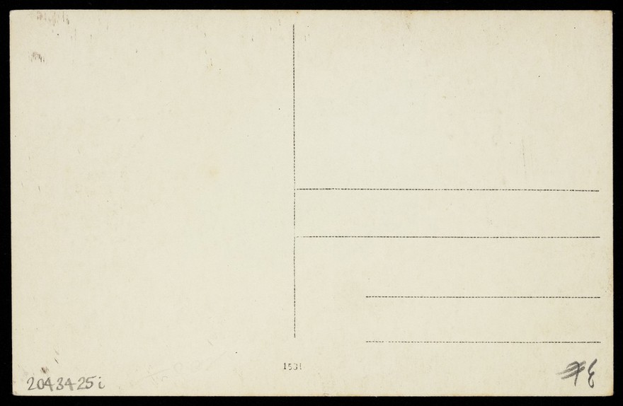 A prisoner of war acting in an internment camp in Dülmen, performing in drag, wearing a white dress and a dark hat. Photographic postcard, 191-.