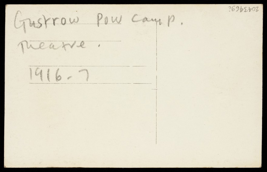 Güstrow prisoner of war camp: the interior of the theatre, including a piano. Photographic postcard, 1916.