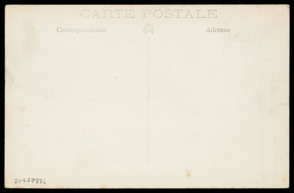 Soldiers, one in drag, with a donkey and cart, posing on the grass in front of trees. Photographic postcard, 191-.