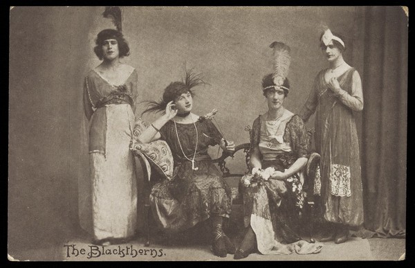 Amateur actors in drag, pose on stage as "The Blackthorns". Photographic postcard, 191-.