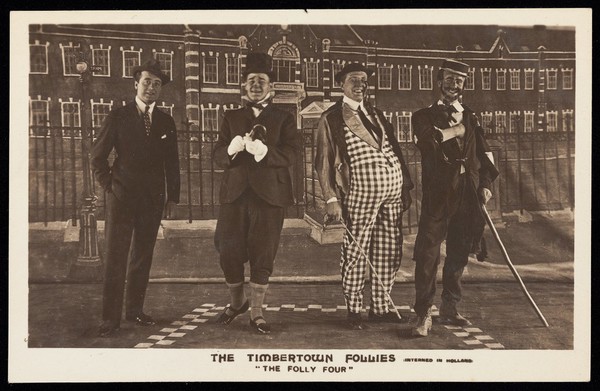 Four British prisoners of war, posing for "The Timbertown Follies", at a prisoner of war camp in Groningen. Photographic postcard, 191-.