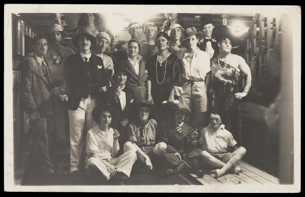 Passengers on RMS Armadale Castle, some in drag, pose for a group portrait. Photographic postcard, 1933.