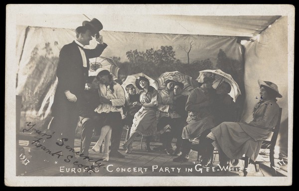 Amateur actors, some in drag, pose on stage in "Gee-Whizz". Photographic postcard, 1917.