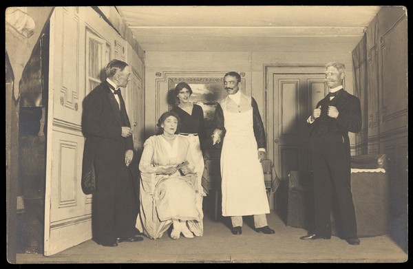 Belgian prisoners of war, some in drag, performing a play at Friedberg camp, Germany . Photographic postcard, 191-.