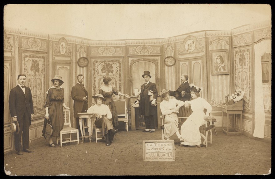 Prisoners of war, some in drag, posing on stage in 'Miquette et sa mere' at Sennelager prisoner of war camp in Germany. Photographic postcard, 191-.