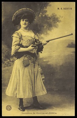 Robert Bertin in drag as Clotilde Alégria, posing with a gun. Process print, 191-.