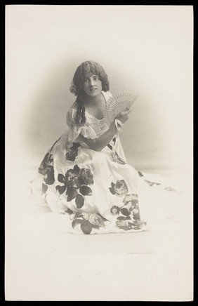 A young man poses in a flowery dress.