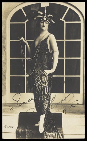 Bert Errol, in character, wearing a shiny black dress. Process print, 1922.