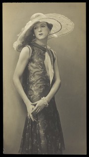 Cecil Beaton, in drag; dressed in a patterned dress. Photograph, ca. 1925.