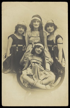 Four performers known as "Madcaps" pose for a portrait in matching costumes.