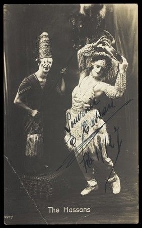 "The Hassans" in character, performing on stage. Photograph, 192-.