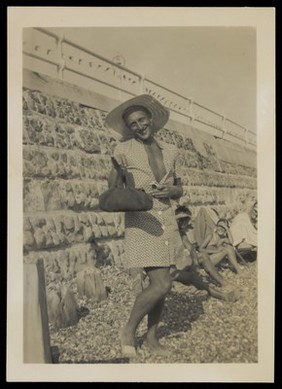 A man poses on a beach.