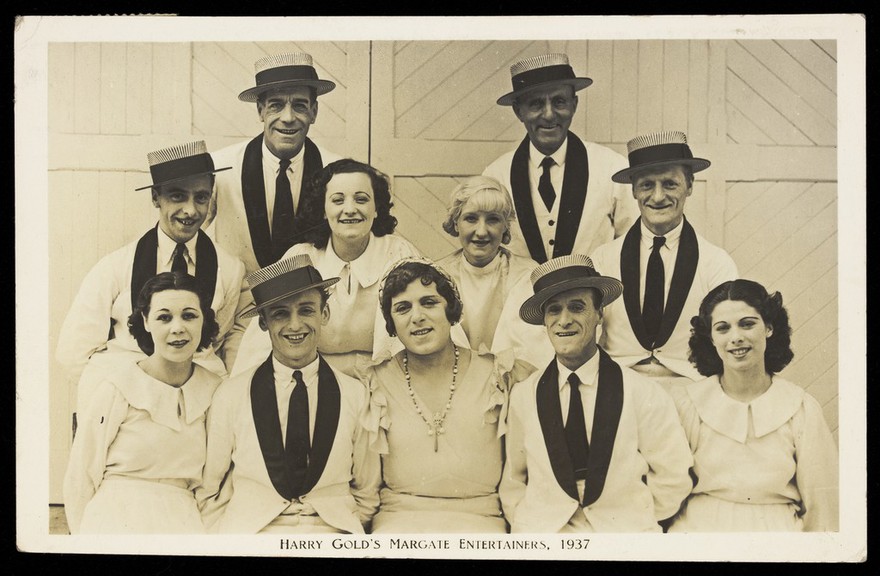 Members of "Harry Gold's Margate Entertainers", one in drag, pose for a group portrait. Photographic postcard, 1937.