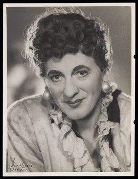 An actor in drag, posing for a portrait. Photograph by Mme Yvonne, 194-.