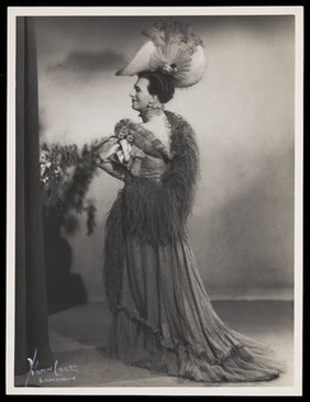 An actor in drag, performing on stage. Photograph by Mme Yvonne, 194-.