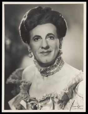 An actor in drag, posing for a portrait. Photograph by Mme Yvonne, 194-.