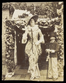 Douglas Byng in drag with a small boy dressed as a man. Photograph, 1911.