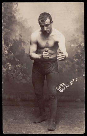 A wrestler poses ready for combat. Photographic postcard, 19--.