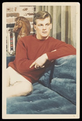 A young man wearing a red jumper and white briefs. Colour photograph, 195-.