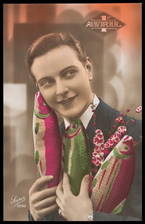 A man holding three fish and some flowers; the fish representing "poissons d'avril" (April fool's jokes). Coloured photographic postcard, 192-.