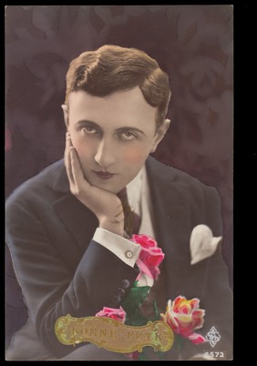 A young man holding flowers. Photographic postcard, 1937.