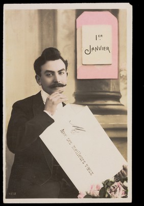 A man holding an envelope above flowers; representing a romantic new year. Coloured photographic postcard, ca. 1910.