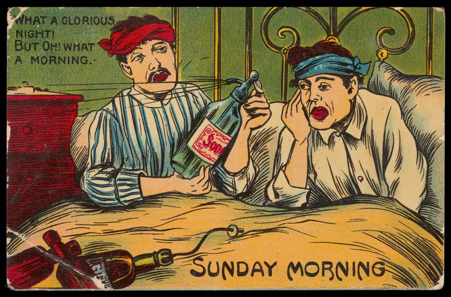 Two young men wake up in bed with headaches on Sunday morning after much drinking the night before. Colour lithograph, 1913.