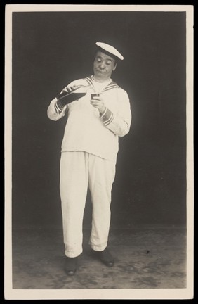 Bert Murray in character as a sailor pouring himself a drink. Photographic postcard, 192-.