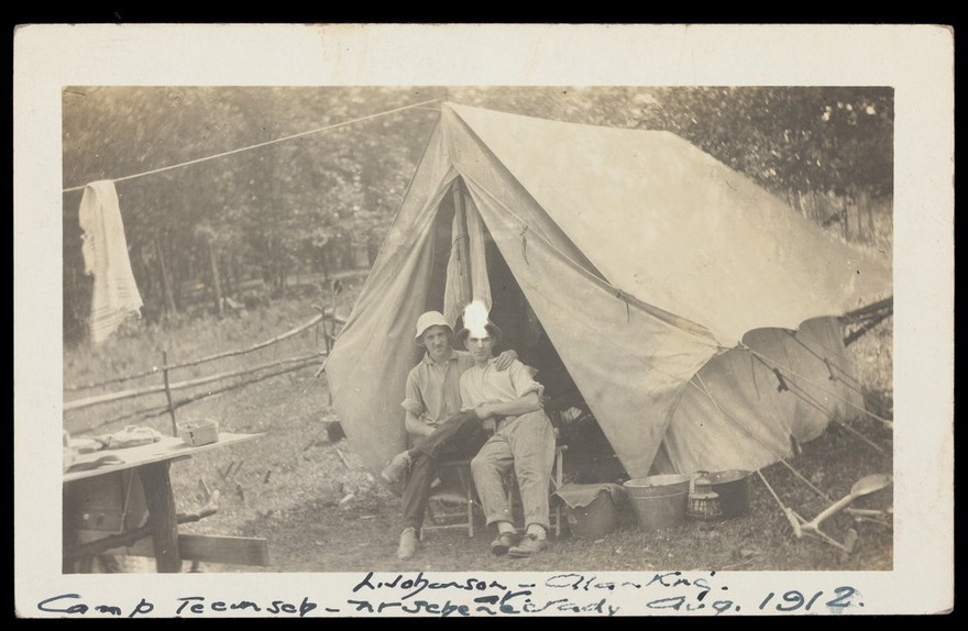 Two men outside their tent at Camp Tecumseh, near Schenectady, New York. Photographic postcard, 1912.