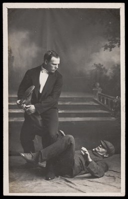 Two men demonstrating jiu-jitsu, wearing formal attire. Photographic postcard, ca. 191-.