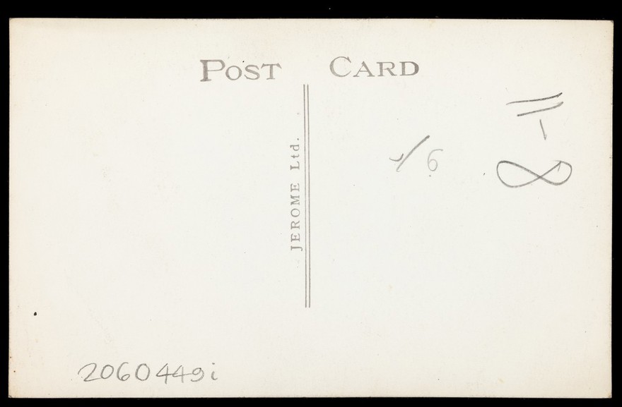 A man wearing a white suit poses by a doorway. Photographic postcard by Jerome Ltd., 192-.