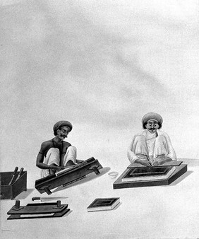 Two Indian bookbinders: one trimming page edges in a press, the other decorating a binding. Watercolour.