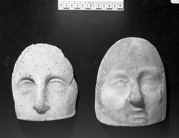 Votive offerings in the form of the face. Apparently terracotta.