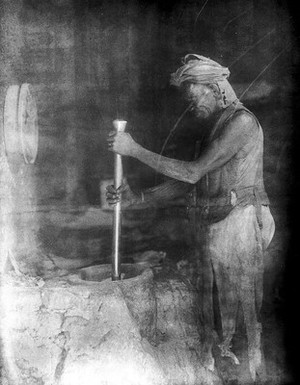 view A man using a mortar and pestle, Sudan (?)