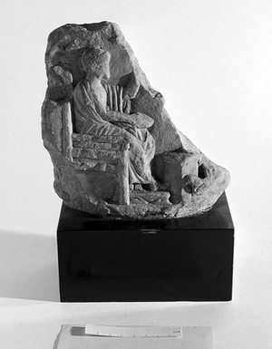view Fragment of votive relief, showing male figure seated