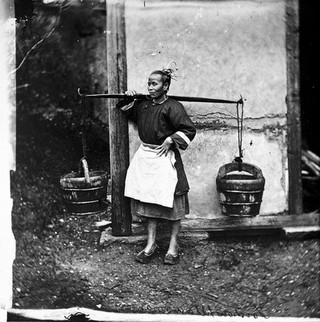 Foochow, Fukien province, China: a woman carrying buckets of night-soil. Photograph, 1981, from a negative by John Thomson, 1869.