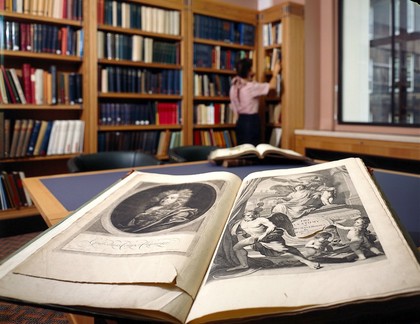 Interior of Wellcome library, shelves in background, and a table showing title page of W. Cowper, The anatomy of humane bodies, 1698