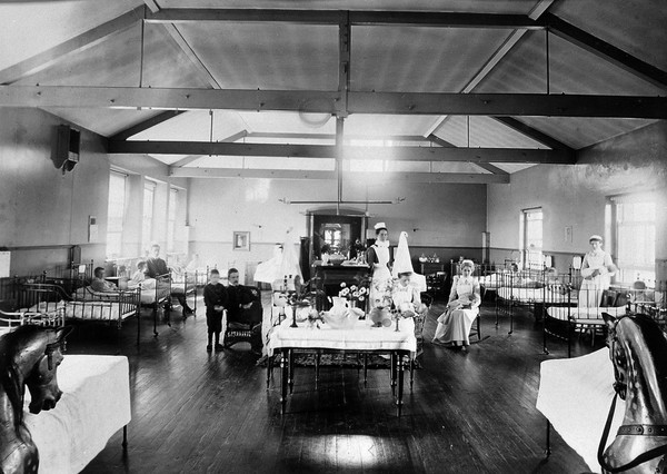 Royal Portsmouth Hospital: children's ward, with patients, nurses and members of the medical staff. Photograph, 1902.