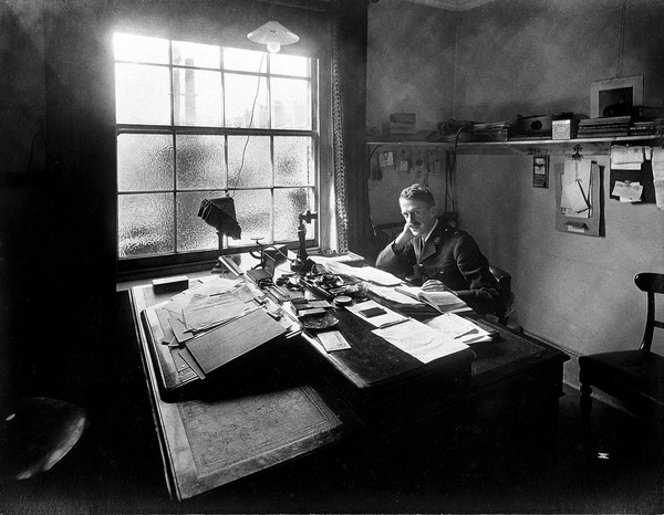 Ambulance Column depot, 9 Gower Street, London: the Deputy Director seated at his desk. Photograph, September 1918.