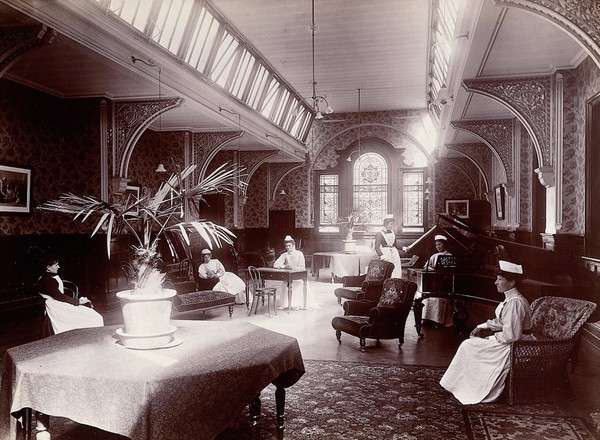 Claybury Asylum, Woodford, Essex: a nurses' day-room (?) Photograph by the London & County Photographic Co., [1893?].