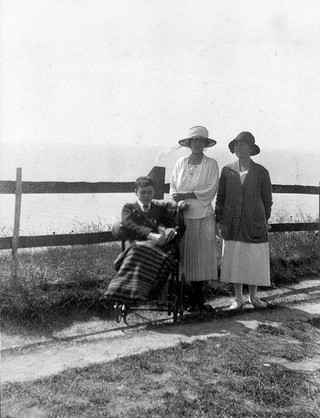 A physically disabled boy sitting in a wheelchair. Photograph, ca. 1910/1925.
