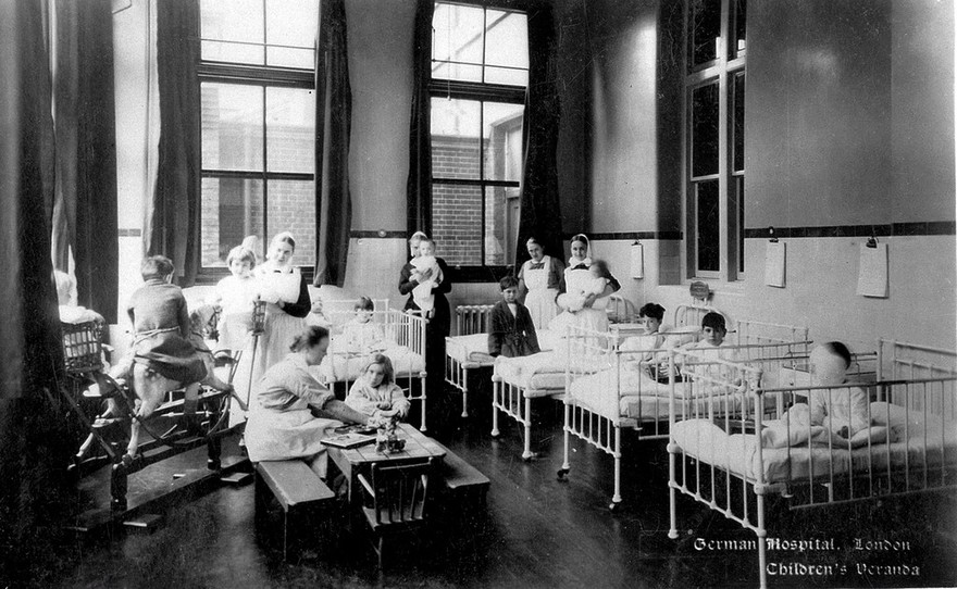 The German Hospital, Dalston: ward ("Veranda") for children, with children and nurses. Photograph by Marshall, Keene & Co.